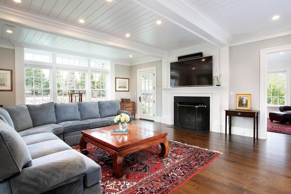 Large traditional open concept family room in Boston with grey walls, dark hardwood floors, a standard fireplace, a stone fireplace surround and a wall-mounted tv.