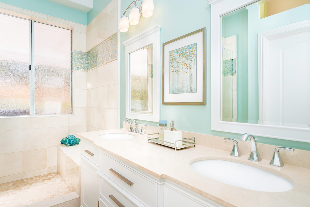 Beach style master bathroom in Los Angeles with an undermount sink, white cabinets, a one-piece toilet, terra-cotta floors, beaded inset cabinets, limestone benchtops, an alcove shower, blue tile, glass tile and blue walls.