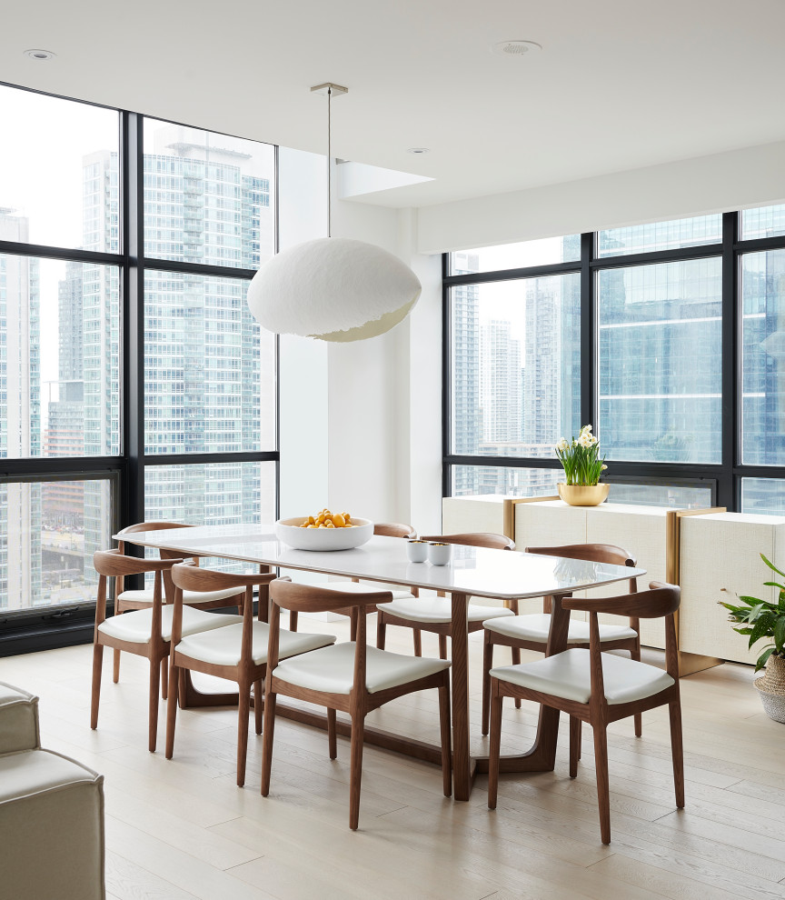 Idee per una sala da pranzo aperta verso la cucina contemporanea di medie dimensioni con pareti bianche, parquet chiaro e pavimento beige
