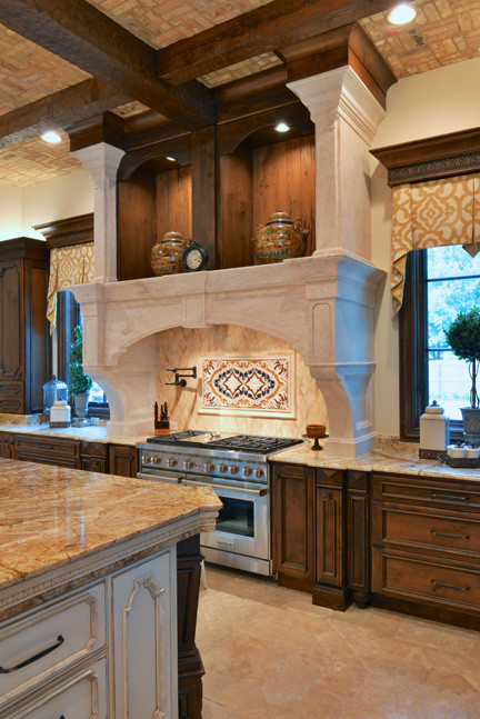 Design ideas for a large traditional u-shaped open plan kitchen in Dallas with recessed-panel cabinets, dark wood cabinets, granite benchtops, beige splashback, stone tile splashback, stainless steel appliances, limestone floors and multiple islands.