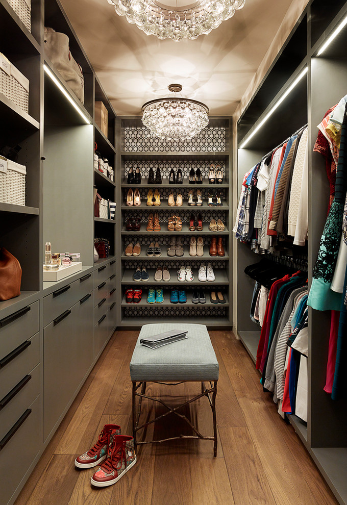 Design ideas for an eclectic women's walk-in wardrobe in San Francisco with flat-panel cabinets, green cabinets, medium hardwood floors and brown floor.