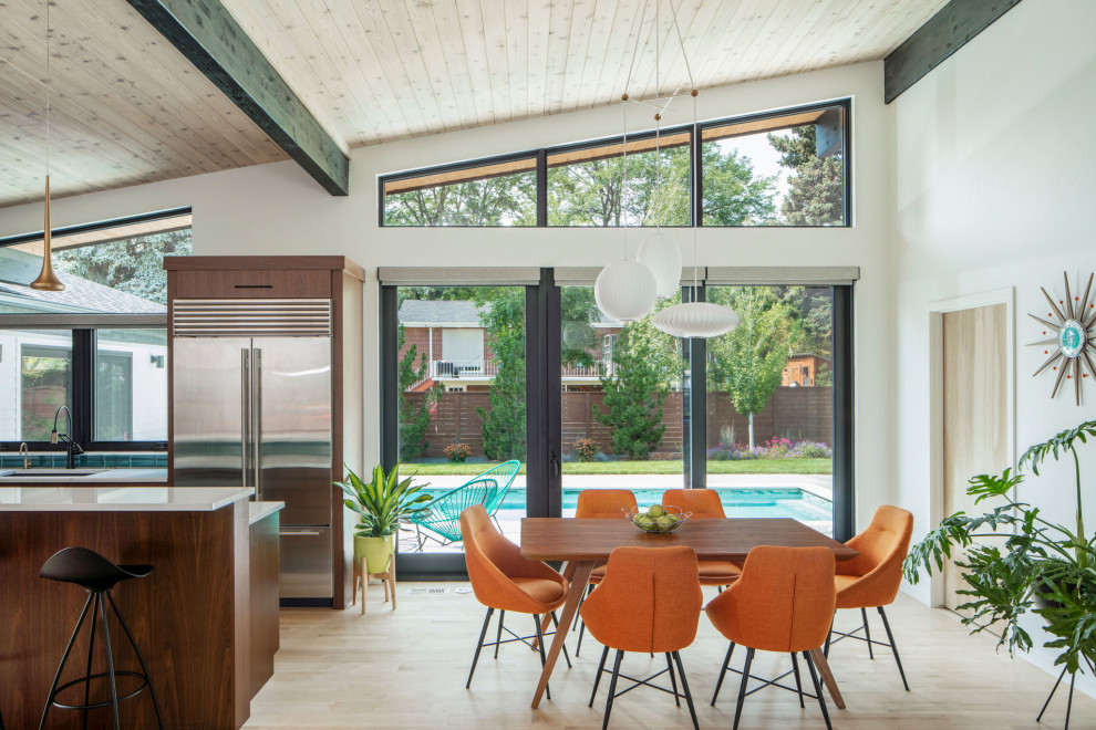 Esempio di una sala da pranzo aperta verso la cucina moderna con pareti bianche, parquet chiaro, nessun camino e soffitto in legno