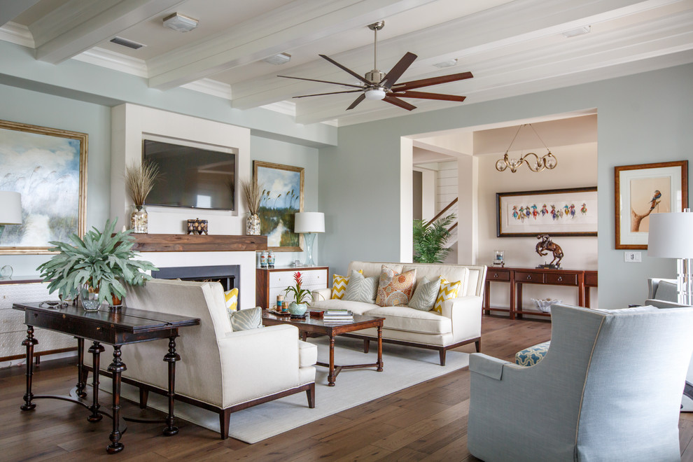 Beach style family room in Jacksonville with blue walls, medium hardwood floors, a standard fireplace, a metal fireplace surround, a wall-mounted tv and brown floor.