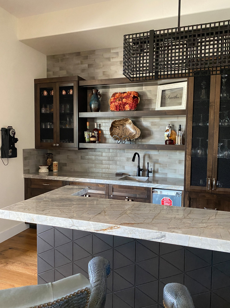 Inspiration for a mid-sized transitional u-shaped seated home bar in Phoenix with an undermount sink, dark wood cabinets, quartzite benchtops, grey splashback, porcelain splashback, medium hardwood floors, brown floor and multi-coloured benchtop.