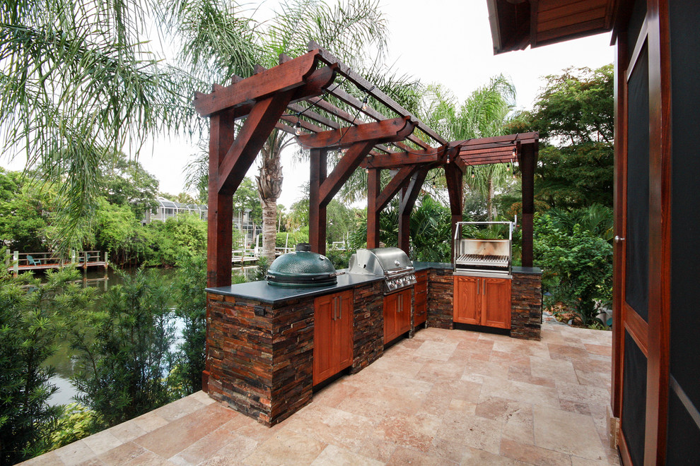 Photo of a large tropical backyard patio in Tampa with an outdoor kitchen, tile and no cover.
