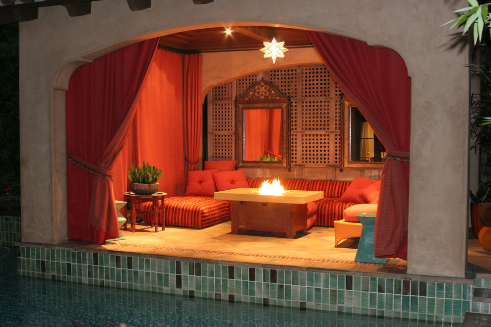 Inspiration for a mid-sized mediterranean backyard patio in Los Angeles with a fire feature, tile and a pergola.