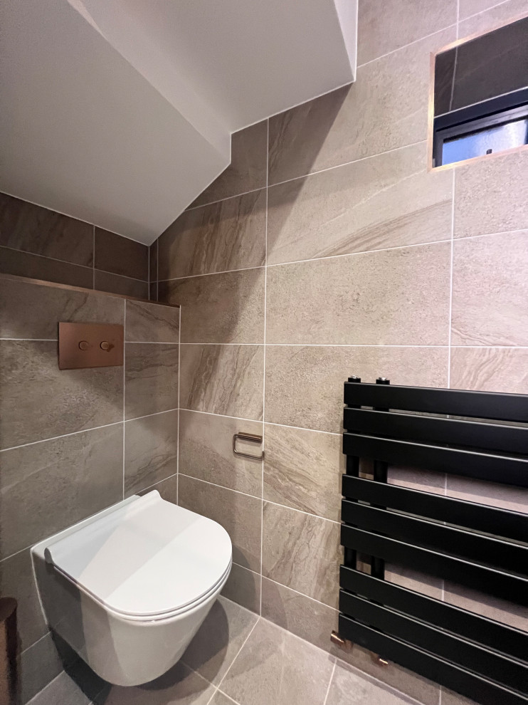 Photo of a medium sized contemporary bathroom with flat-panel cabinets, beige cabinets, a wall mounted toilet, porcelain tiles, brown walls, porcelain flooring, a built-in sink, beige floors, an open shower, a feature wall, a single sink and a floating vanity unit.