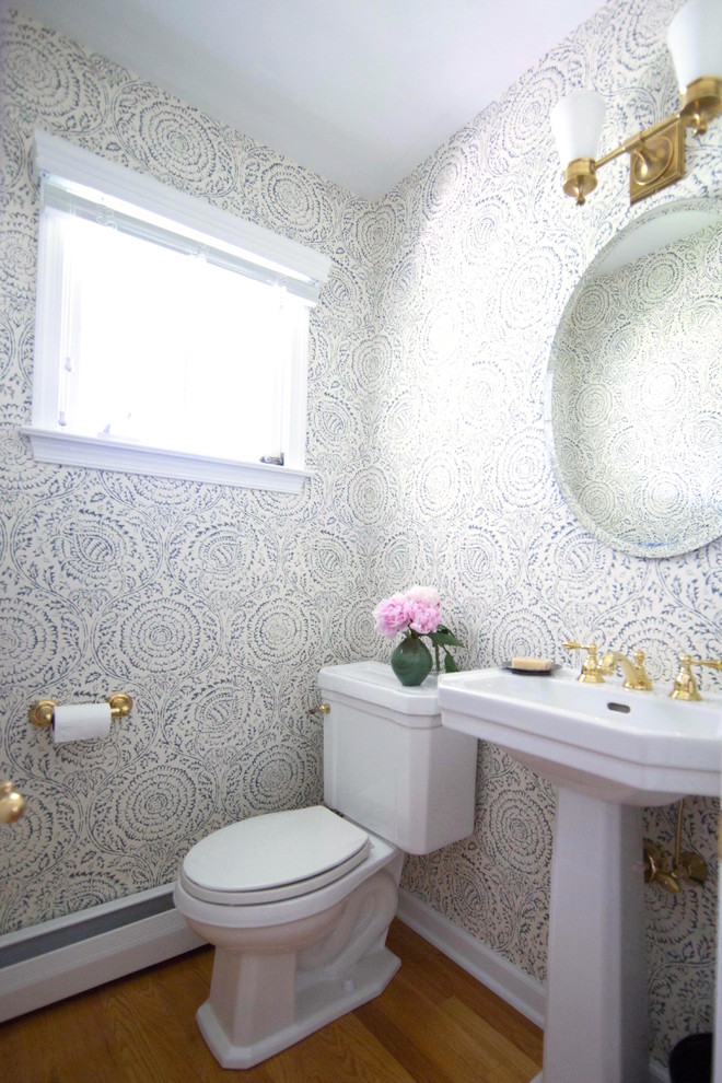 Example of a small transitional medium tone wood floor and brown floor powder room design in Philadelphia with a two-piece toilet, blue walls and a pedestal sink