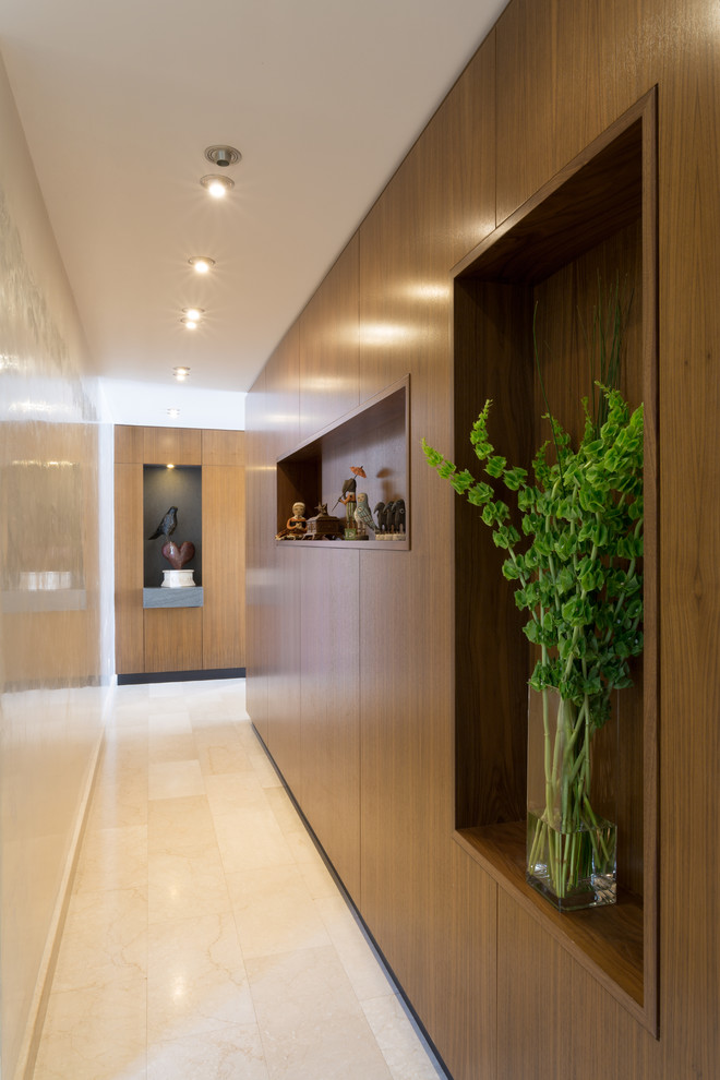 Mid-sized modern hallway in New York with beige walls, marble floors and beige floor.