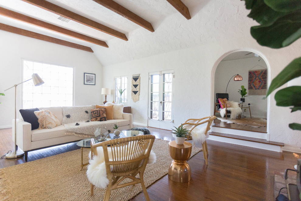 Tuscan medium tone wood floor and brown floor living room photo in Los Angeles with white walls