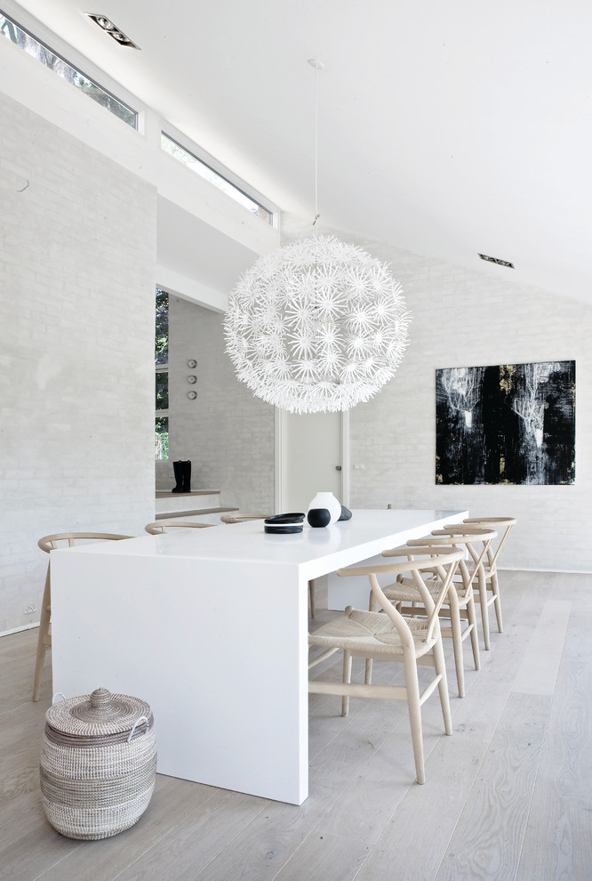 Photo of a large scandinavian separate dining room in Copenhagen with white walls and painted wood floors.