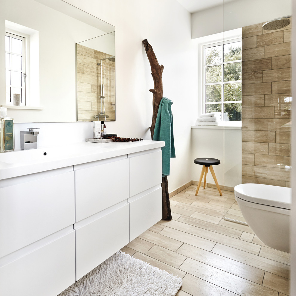 This is an example of a mid-sized scandinavian master bathroom in Aarhus with flat-panel cabinets, white cabinets, a curbless shower, a wall-mount toilet, white walls, ceramic floors, an integrated sink and laminate benchtops.