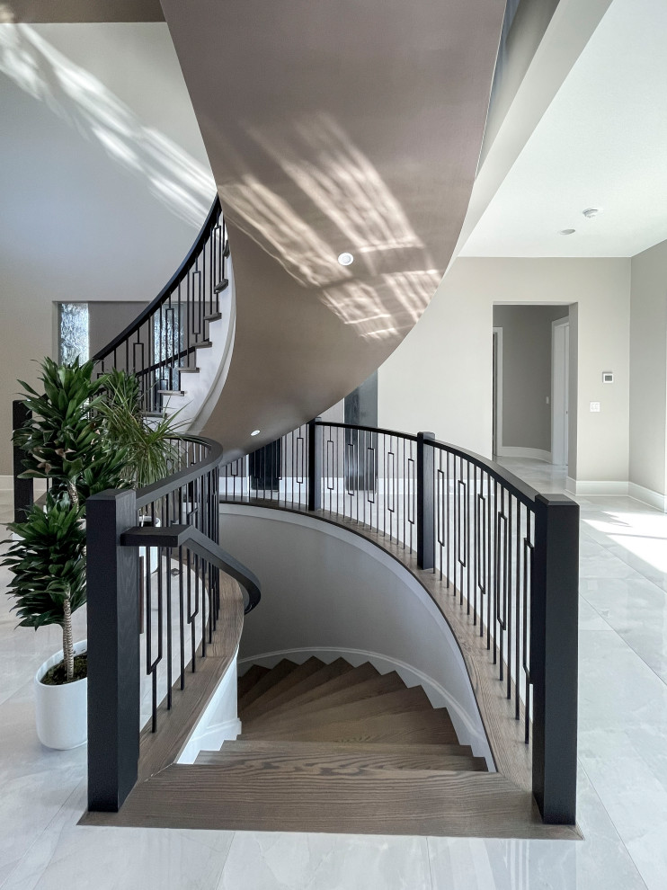 Design ideas for an expansive transitional wood curved staircase in DC Metro with painted wood risers, mixed railing and wallpaper.