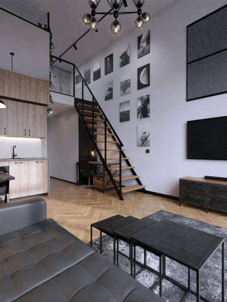 Mid-sized industrial open plan kitchen in Berlin with a drop-in sink, black appliances, light hardwood floors and no island.