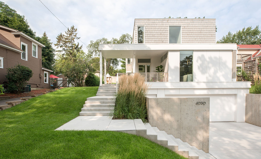 This is an example of a mid-sized modern front yard verandah in Minneapolis with concrete slab and a roof extension.