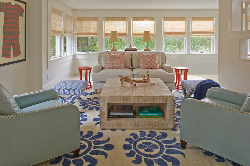 This is an example of a mid-sized beach style enclosed living room in New York with white walls and light hardwood floors.