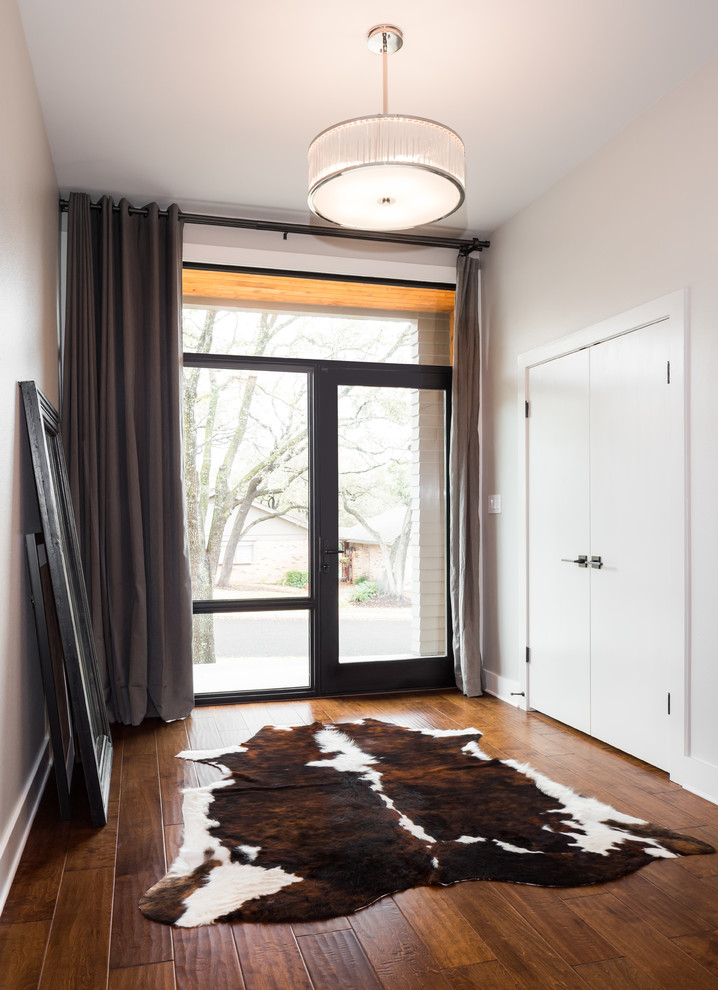 Inspiration for a transitional medium tone wood floor foyer remodel in Austin with gray walls and a black front door
