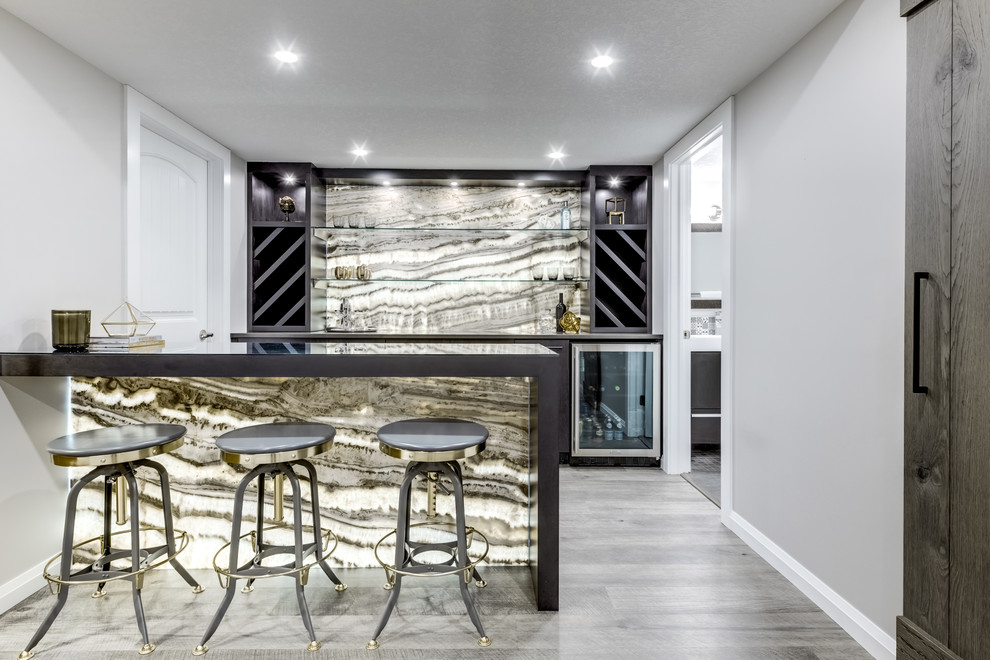 Photo of a mid-sized contemporary galley seated home bar in Calgary with no sink, flat-panel cabinets, brown cabinets, quartz benchtops, multi-coloured splashback, stone slab splashback, vinyl floors, grey floor and brown benchtop.