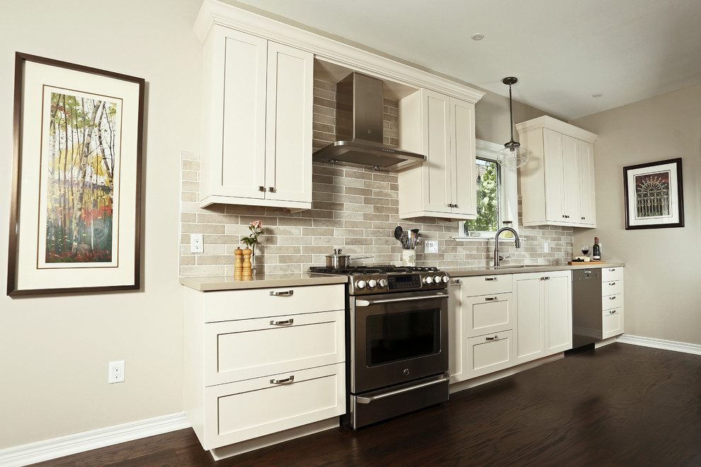 Mid-sized transitional galley dark wood floor and brown floor open concept kitchen photo with an undermount sink, shaker cabinets, beige cabinets, quartz countertops, beige backsplash, porcelain backsplash, stainless steel appliances and no island