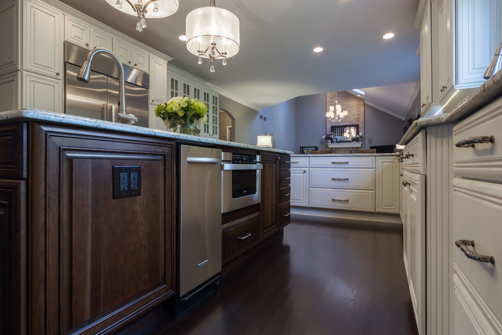 Large transitional u-shaped dark wood floor kitchen photo in Chicago with a double-bowl sink, raised-panel cabinets, white cabinets, granite countertops, gray backsplash, subway tile backsplash, stainless steel appliances and an island