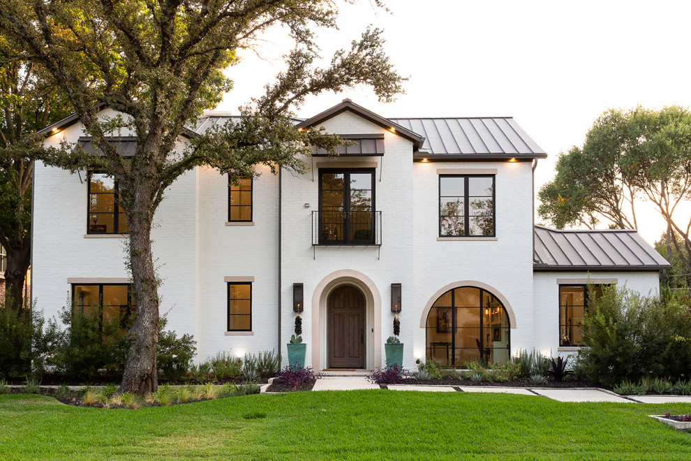 Design ideas for a mediterranean two-storey brick white house exterior in Dallas with a gable roof, a metal roof and a grey roof.