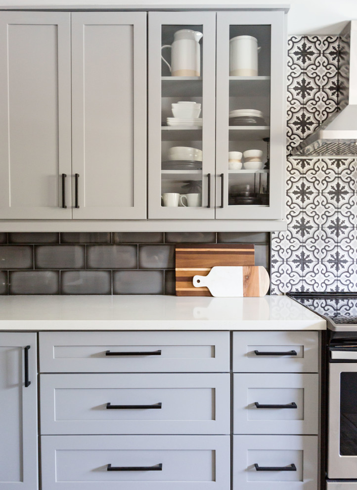 Example of a mid-sized transitional u-shaped light wood floor and gray floor eat-in kitchen design in Phoenix with an undermount sink, recessed-panel cabinets, gray cabinets, quartz countertops, multicolored backsplash, ceramic backsplash, stainless steel appliances, an island and white countertops