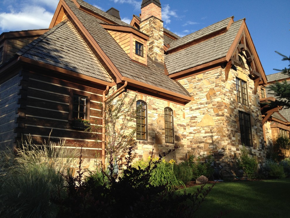 Large rustic brown three-story stone gable roof idea