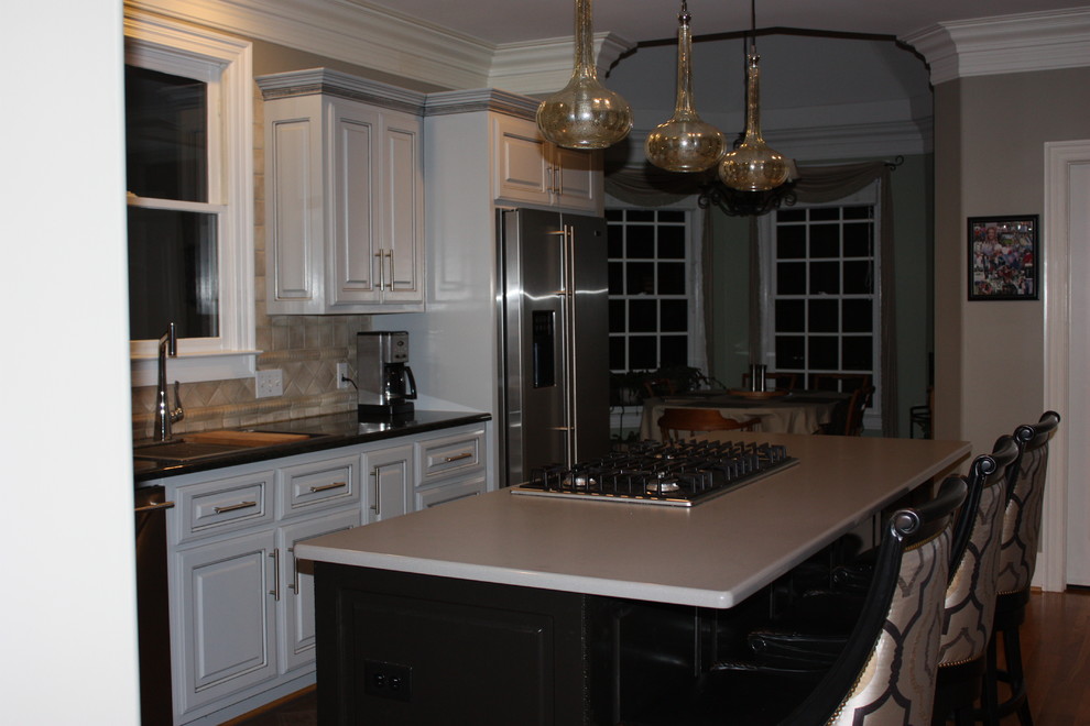 Eat-in kitchen - large transitional u-shaped light wood floor eat-in kitchen idea with a double-bowl sink, raised-panel cabinets, gray cabinets, quartz countertops, beige backsplash, ceramic backsplash, stainless steel appliances and an island