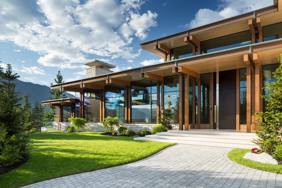 This is an example of an expansive contemporary two-storey brown house exterior in Vancouver with a flat roof.