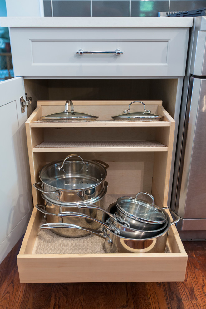 Inspiration for a mid-sized transitional l-shaped medium tone wood floor eat-in kitchen remodel in Bridgeport with an undermount sink, recessed-panel cabinets, gray cabinets, granite countertops, black backsplash, ceramic backsplash, stainless steel appliances and an island