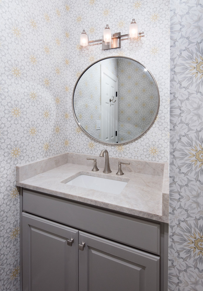 Design ideas for a small transitional powder room in Austin with raised-panel cabinets, grey cabinets, a one-piece toilet, dark hardwood floors, an undermount sink, brown floor, beige walls, engineered quartz benchtops and beige benchtops.