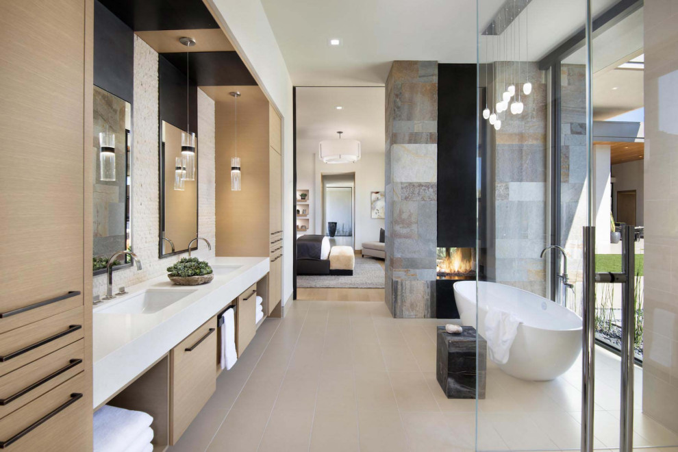 Design ideas for an expansive contemporary master bathroom in Phoenix with flat-panel cabinets, medium wood cabinets, a freestanding tub, a double shower, beige tile, porcelain tile, white walls, an undermount sink, engineered quartz benchtops, beige floor, a hinged shower door, white benchtops, an enclosed toilet, a double vanity and a built-in vanity.