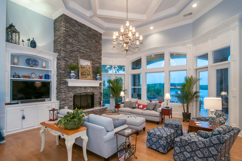 Photo of an expansive eclectic formal open concept living room in Charlotte with blue walls, medium hardwood floors, a standard fireplace, a stone fireplace surround and a built-in media wall.