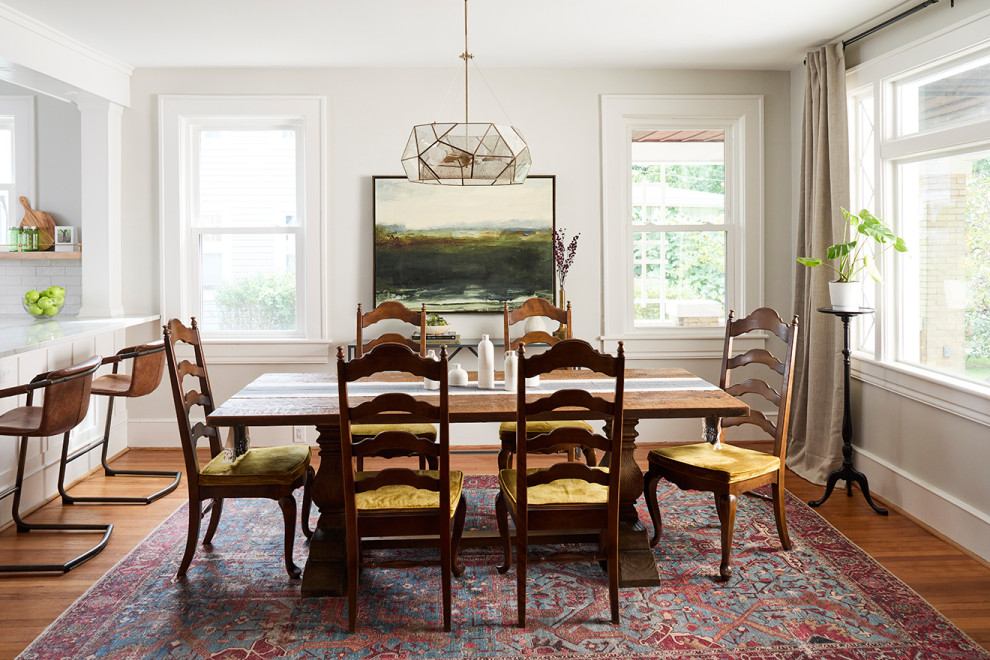 Foto di una grande sala da pranzo aperta verso la cucina classica con pareti bianche, parquet chiaro e pavimento marrone