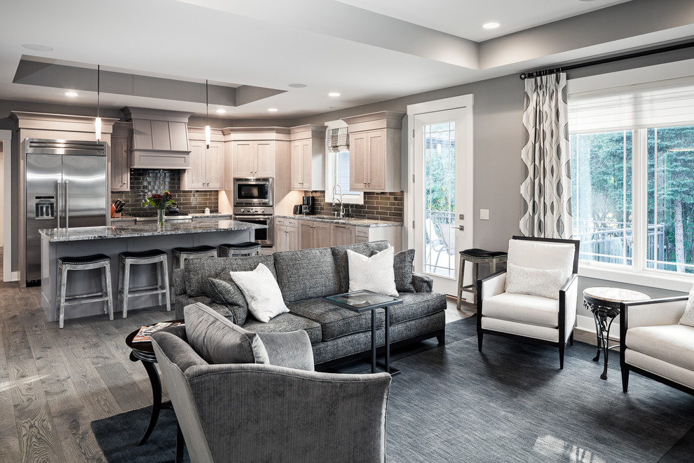 Inspiration for a mid-sized modern open concept living room in Grand Rapids with grey walls, medium hardwood floors, a standard fireplace, a stone fireplace surround, a wall-mounted tv and brown floor.