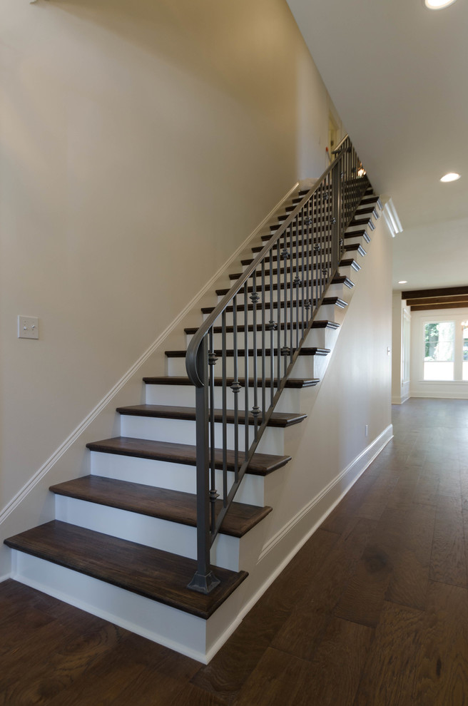 Photo of a large traditional wood straight staircase in New Orleans with wood risers.