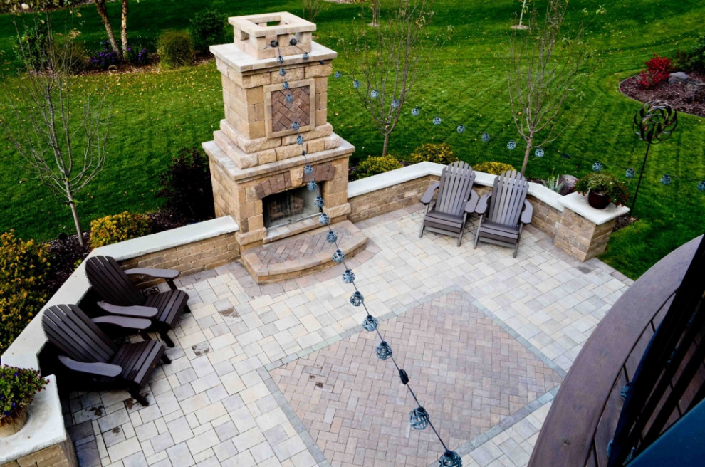 Photo of a mid-sized traditional backyard patio in Minneapolis with with fireplace and brick pavers.