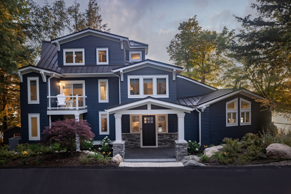 Inspiration pour une grande façade de maison bleue traditionnelle à trois étages et plus avec un revêtement en vinyle, un toit en métal et un toit gris.