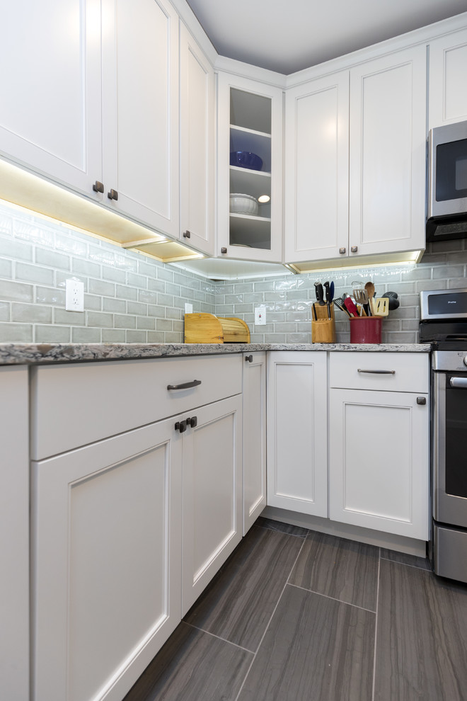 Enclosed kitchen - mid-sized transitional l-shaped porcelain tile and brown floor enclosed kitchen idea in San Diego with an undermount sink, beaded inset cabinets, white cabinets, granite countertops, gray backsplash, ceramic backsplash, stainless steel appliances, no island and gray countertops