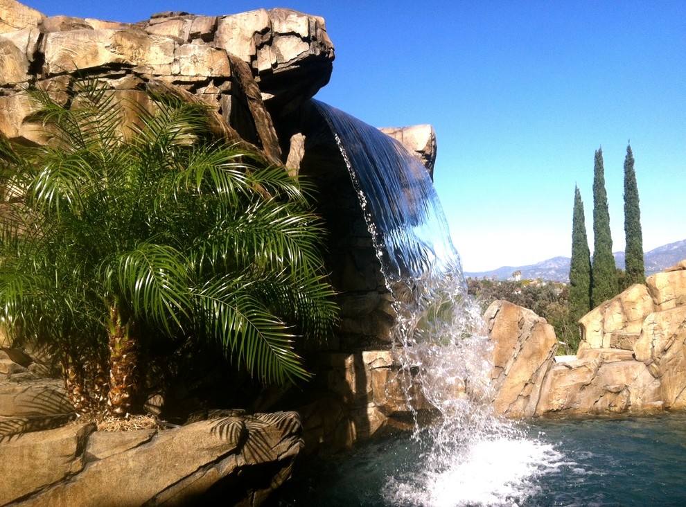 Pool fountain - mid-sized rustic backyard custom-shaped natural pool fountain idea in Orange County