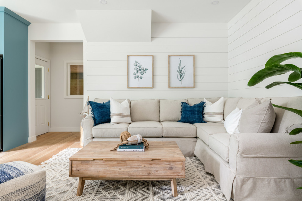 Foto di un soggiorno stile marino con pareti bianche, parquet chiaro, pavimento beige e pareti in perlinato