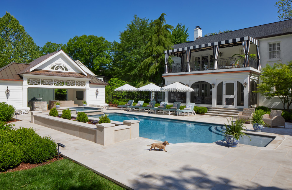 Immagine di un'ampia piscina tradizionale personalizzata dietro casa con piastrelle e una dépendance a bordo piscina