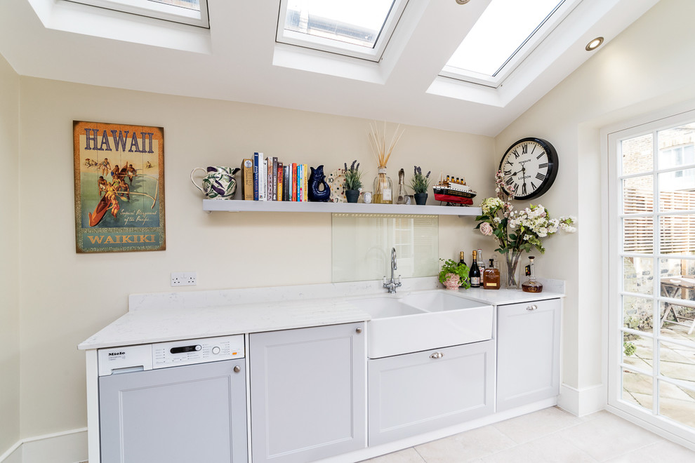 Photo of a mid-sized transitional galley eat-in kitchen in London with grey cabinets, porcelain floors and with island.