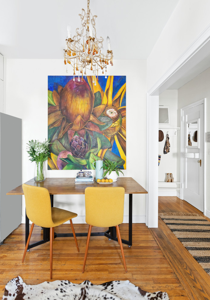 Design ideas for a small eclectic dining room in New York with white walls and light hardwood floors.