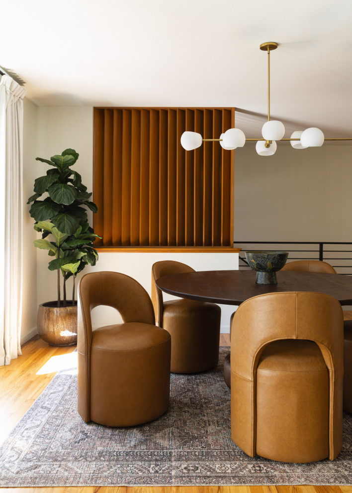 Example of a 1950s medium tone wood floor and brown floor dining room design in Portland with white walls