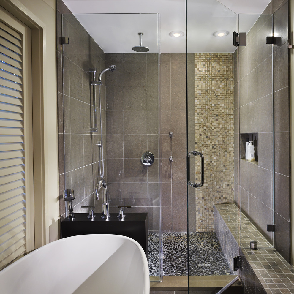 Inspiration for a mid-sized contemporary master bathroom in DC Metro with stone tile, pebble tile floors, a vessel sink, flat-panel cabinets, medium wood cabinets, a freestanding tub, a corner shower, a one-piece toilet, beige tile and beige walls.