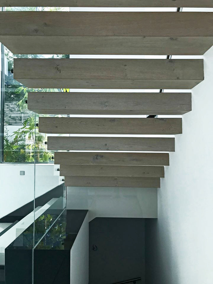 Aménagement d'un escalier droit contemporain avec des marches en bois et un garde-corps en verre.