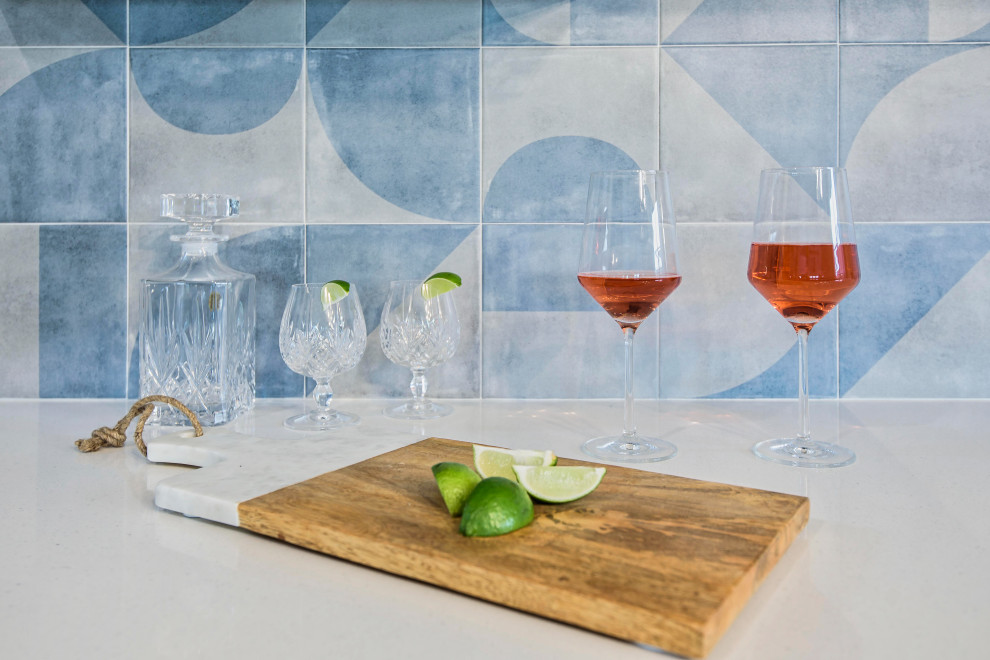 Inspiration for a mid-sized modern single-wall home bar in Austin with shaker cabinets, blue cabinets, quartzite benchtops, blue splashback, ceramic splashback, ceramic floors, brown floor and white benchtop.