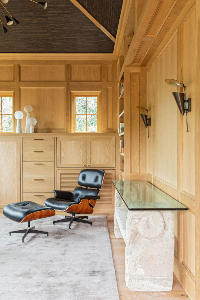 Diseño de despacho abovedado mediterráneo grande con paredes marrones, suelo de madera clara, escritorio empotrado y suelo marrón
