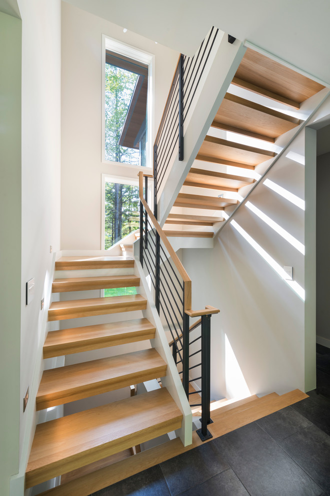 Small contemporary wood u-shaped staircase in Boston with open risers.
